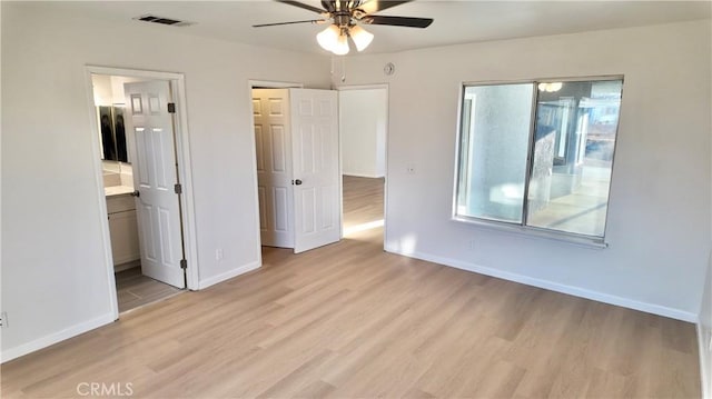 unfurnished bedroom with ceiling fan, light wood-type flooring, and connected bathroom