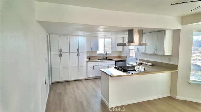 kitchen featuring white cabinets, dishwasher, extractor fan, sink, and kitchen peninsula