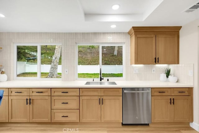 kitchen with decorative backsplash, sink, light brown cabinets, and stainless steel dishwasher