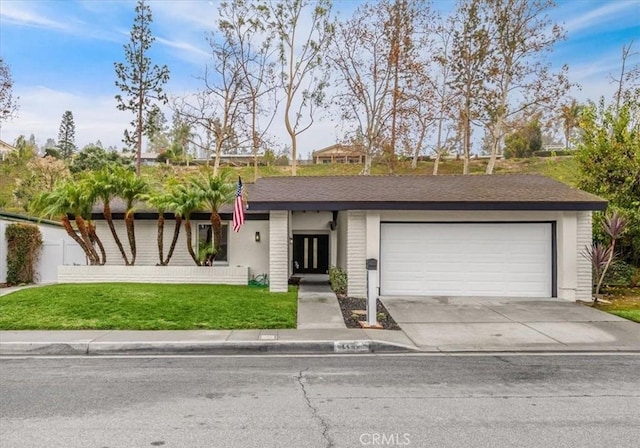 ranch-style house featuring a garage and a front yard