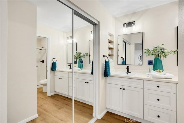 bathroom featuring wood-type flooring, toilet, and vanity