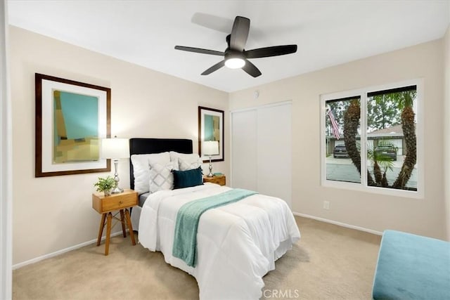 carpeted bedroom featuring ceiling fan and a closet