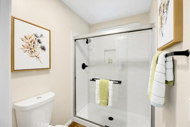 bathroom with toilet and a shower with shower door