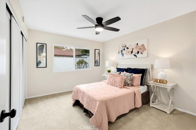 carpeted bedroom with ceiling fan and a closet