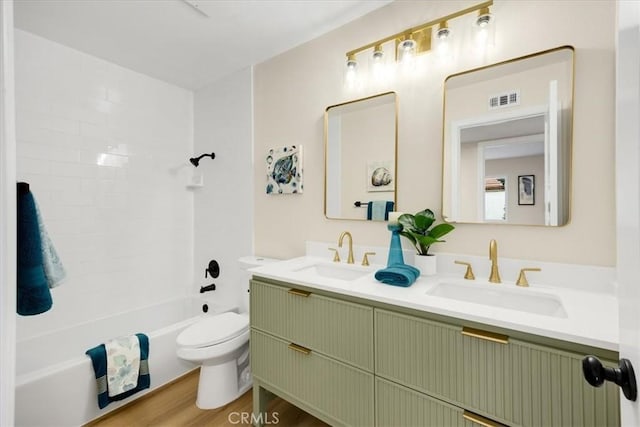 full bathroom featuring toilet, vanity,  shower combination, and hardwood / wood-style flooring