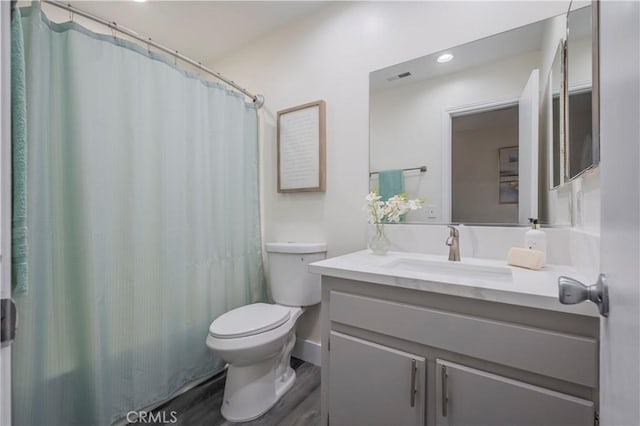 bathroom with toilet, vanity, a shower with curtain, and hardwood / wood-style flooring