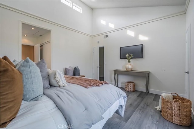 bedroom featuring hardwood / wood-style flooring and high vaulted ceiling