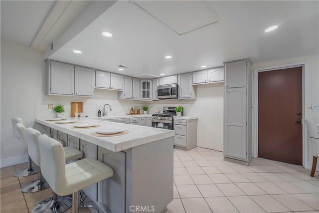 kitchen with a breakfast bar area, kitchen peninsula, sink, and stainless steel appliances