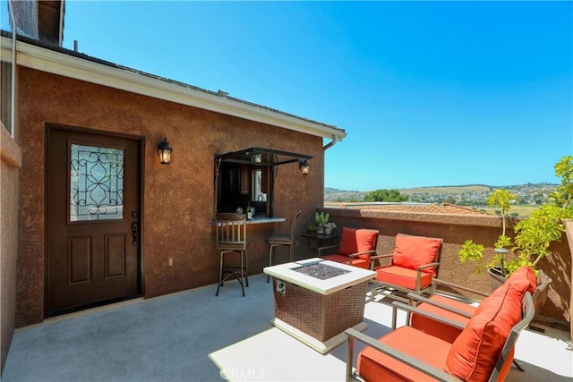 view of patio with an outdoor bar and a fire pit