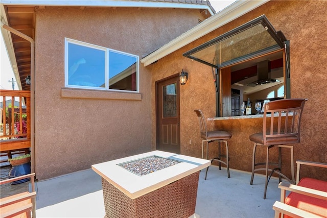 view of patio / terrace featuring an outdoor fire pit and exterior bar