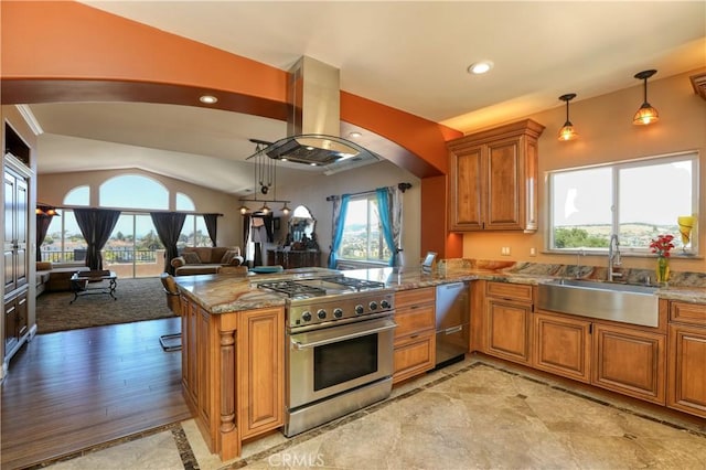 kitchen featuring kitchen peninsula, sink, decorative light fixtures, island range hood, and stainless steel appliances