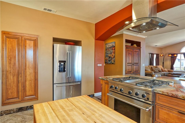 kitchen featuring light tile patterned flooring, high end appliances, and island exhaust hood