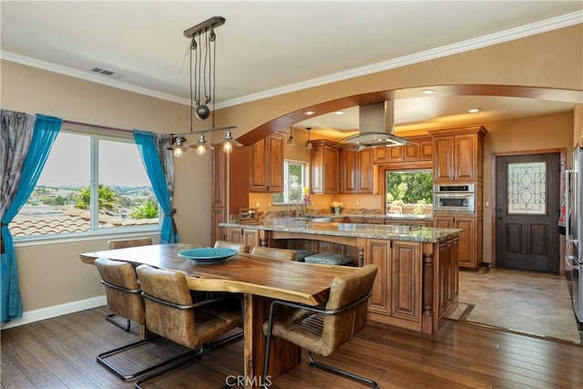 dining space with sink, ornamental molding, and dark wood-type flooring