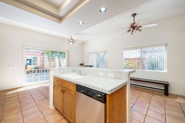 kitchen featuring a center island, tile counters, stainless steel dishwasher, sink, and light tile patterned floors