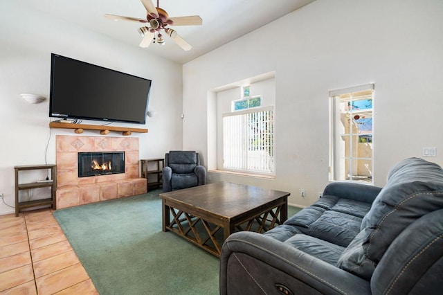 living room with ceiling fan, tile patterned floors, and a tiled fireplace