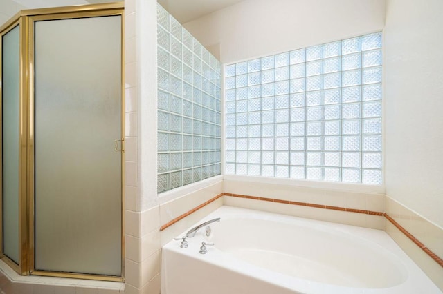 bathroom featuring plenty of natural light and independent shower and bath