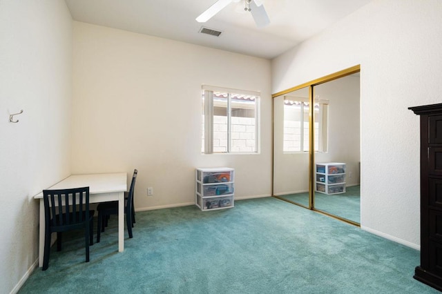 carpeted office space featuring ceiling fan