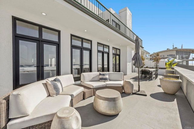 view of patio with an outdoor hangout area, french doors, and a balcony