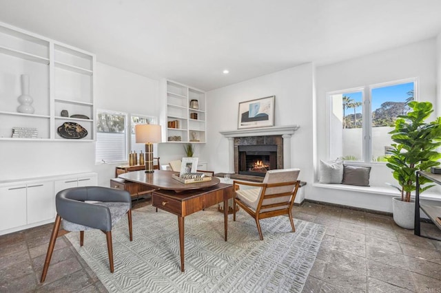 office area with a tiled fireplace