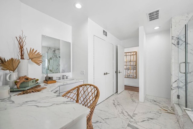 bathroom with a shower with shower door and vanity