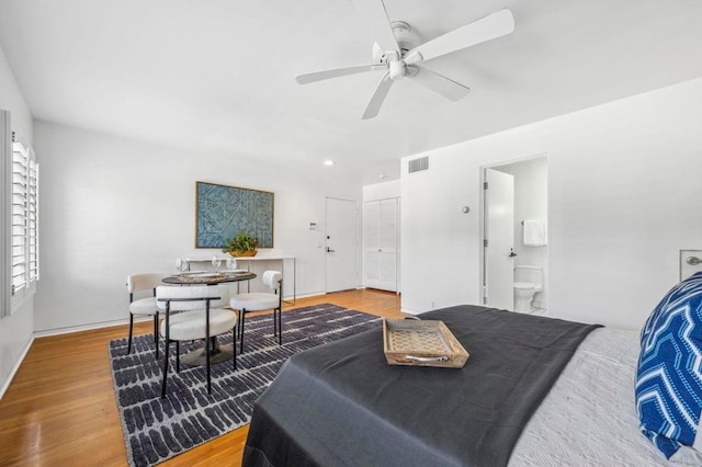 bedroom featuring ensuite bath, ceiling fan, and hardwood / wood-style flooring