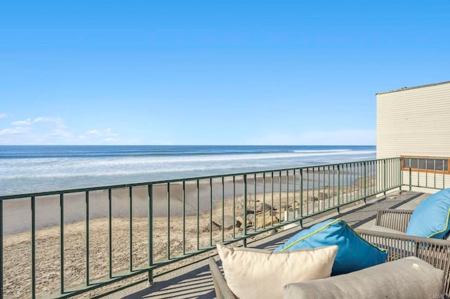 balcony featuring a water view and a view of the beach