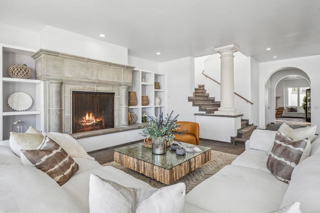 living room with built in shelves and a tile fireplace