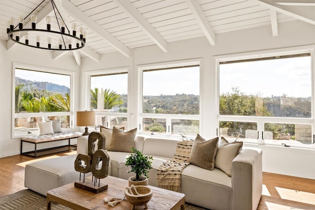 sunroom / solarium with a chandelier, beam ceiling, and plenty of natural light