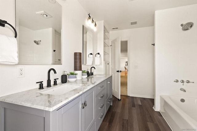 bathroom featuring hardwood / wood-style flooring, shower / bathing tub combination, and vanity