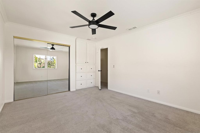 unfurnished bedroom with light carpet, ceiling fan, ornamental molding, and a closet