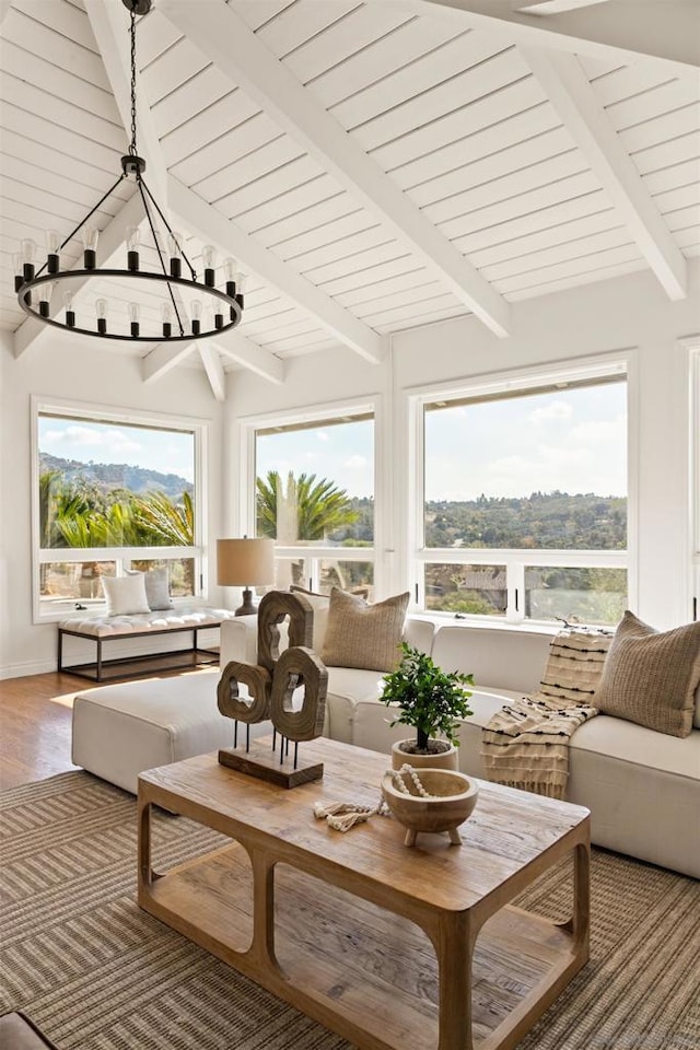 sunroom with beam ceiling and an inviting chandelier