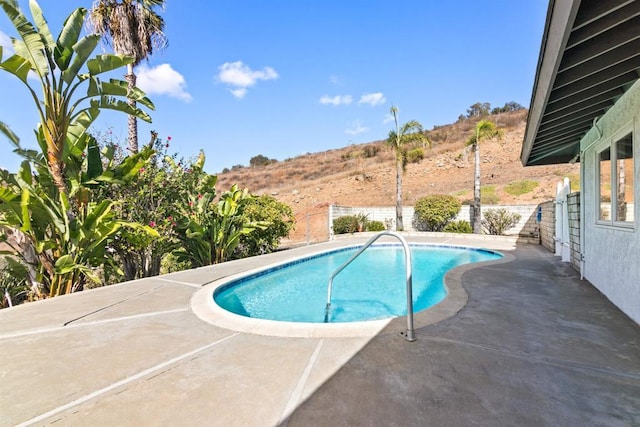 view of pool featuring a mountain view and a patio