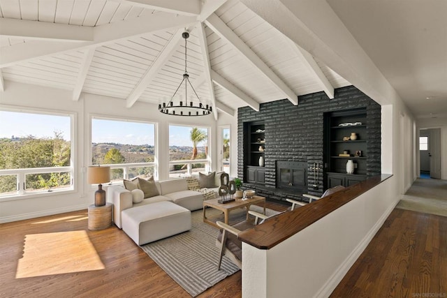 living room featuring a brick fireplace, dark hardwood / wood-style floors, and built in shelves