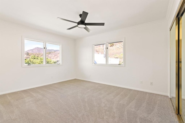 unfurnished bedroom featuring ceiling fan, crown molding, a closet, and light carpet