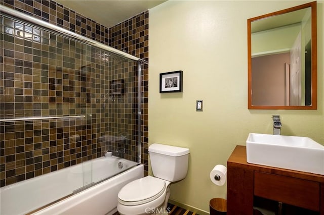 full bathroom featuring enclosed tub / shower combo, toilet, and vanity