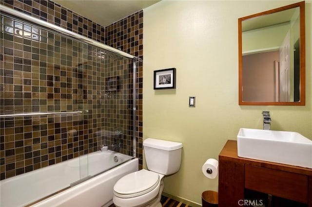 full bathroom featuring toilet, vanity, and bath / shower combo with glass door