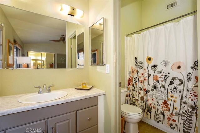 bathroom featuring toilet, vanity, a shower with shower curtain, and ceiling fan