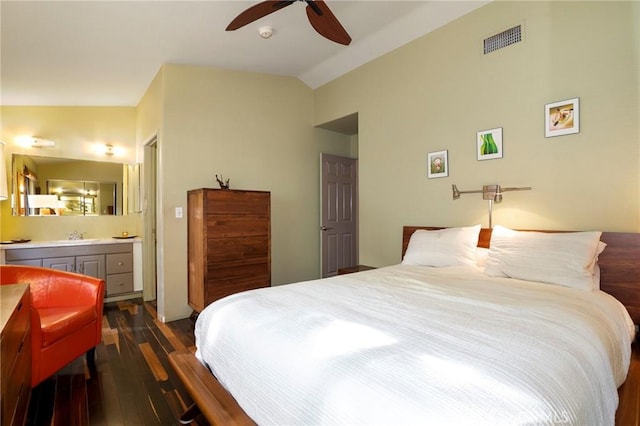 bedroom with ceiling fan, vaulted ceiling, ensuite bath, sink, and dark hardwood / wood-style flooring