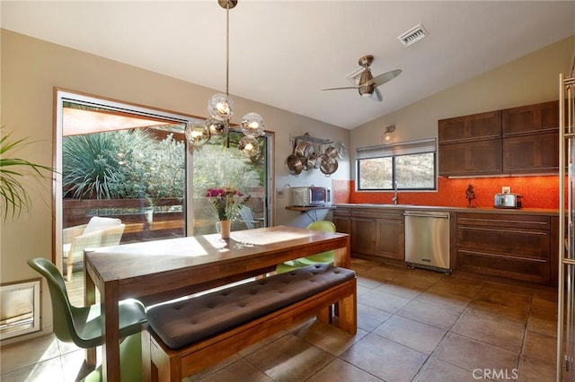 dining space with ceiling fan, vaulted ceiling, and tile patterned floors