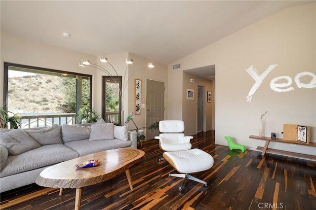 living room featuring vaulted ceiling and dark hardwood / wood-style flooring