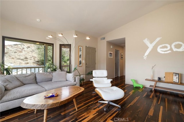 living room featuring lofted ceiling and dark hardwood / wood-style floors