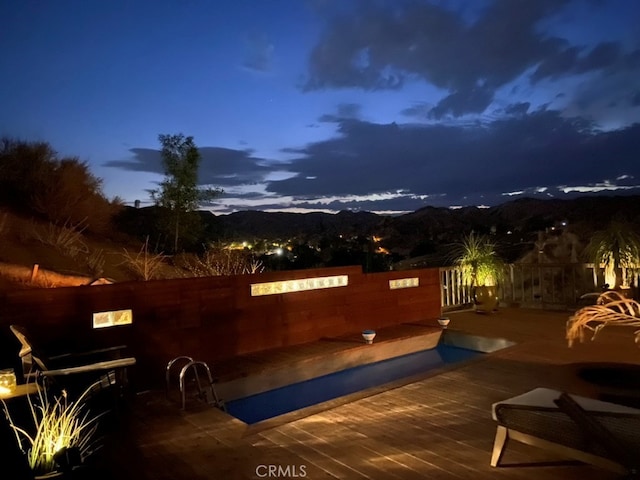 pool at dusk featuring a mountain view