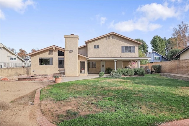 rear view of property with a patio area and a yard