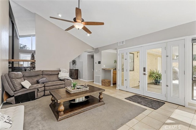 tiled living room with high vaulted ceiling, ceiling fan, and french doors