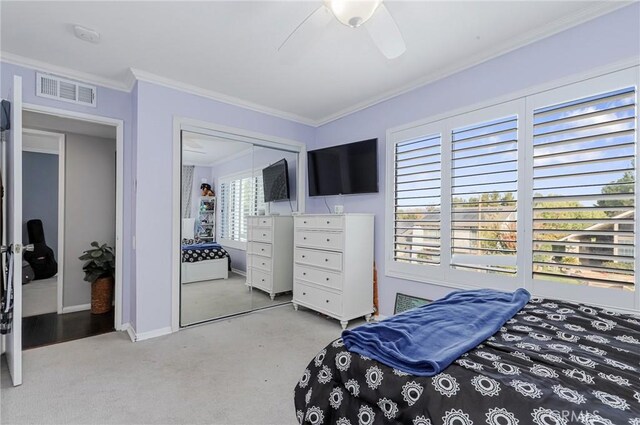 carpeted bedroom with ceiling fan and ornamental molding