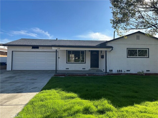 ranch-style house with a garage and a front lawn