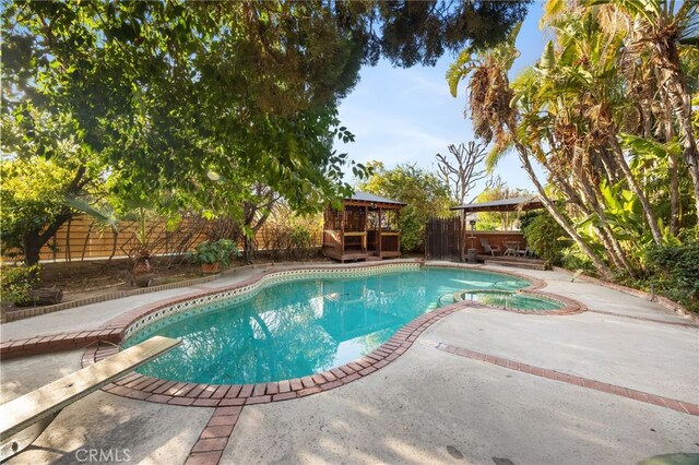 view of pool featuring a gazebo, a diving board, and a patio