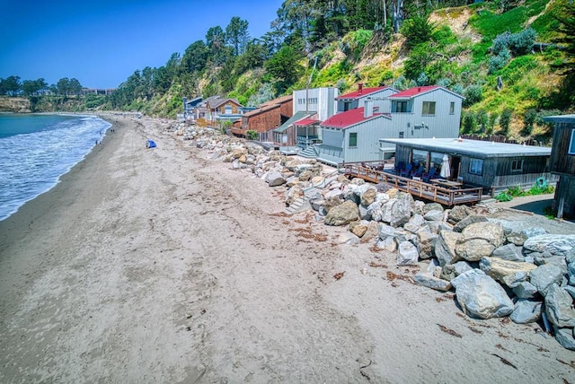 exterior space with a water view and a view of the beach