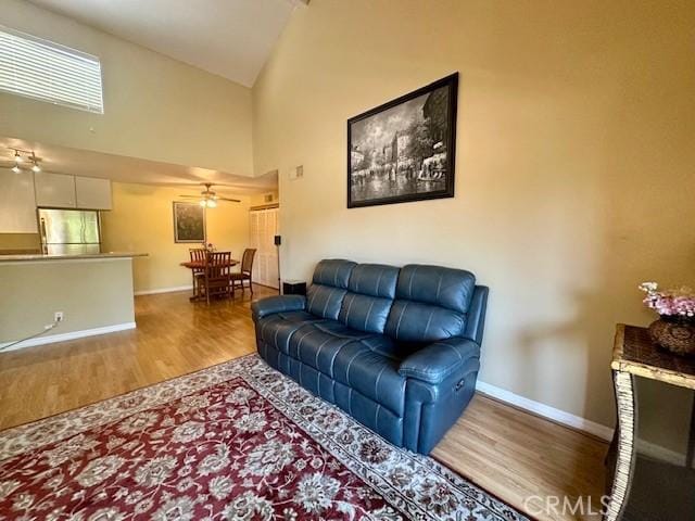 living room featuring high vaulted ceiling, hardwood / wood-style floors, and ceiling fan