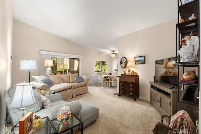 living room with ceiling fan, light colored carpet, and vaulted ceiling